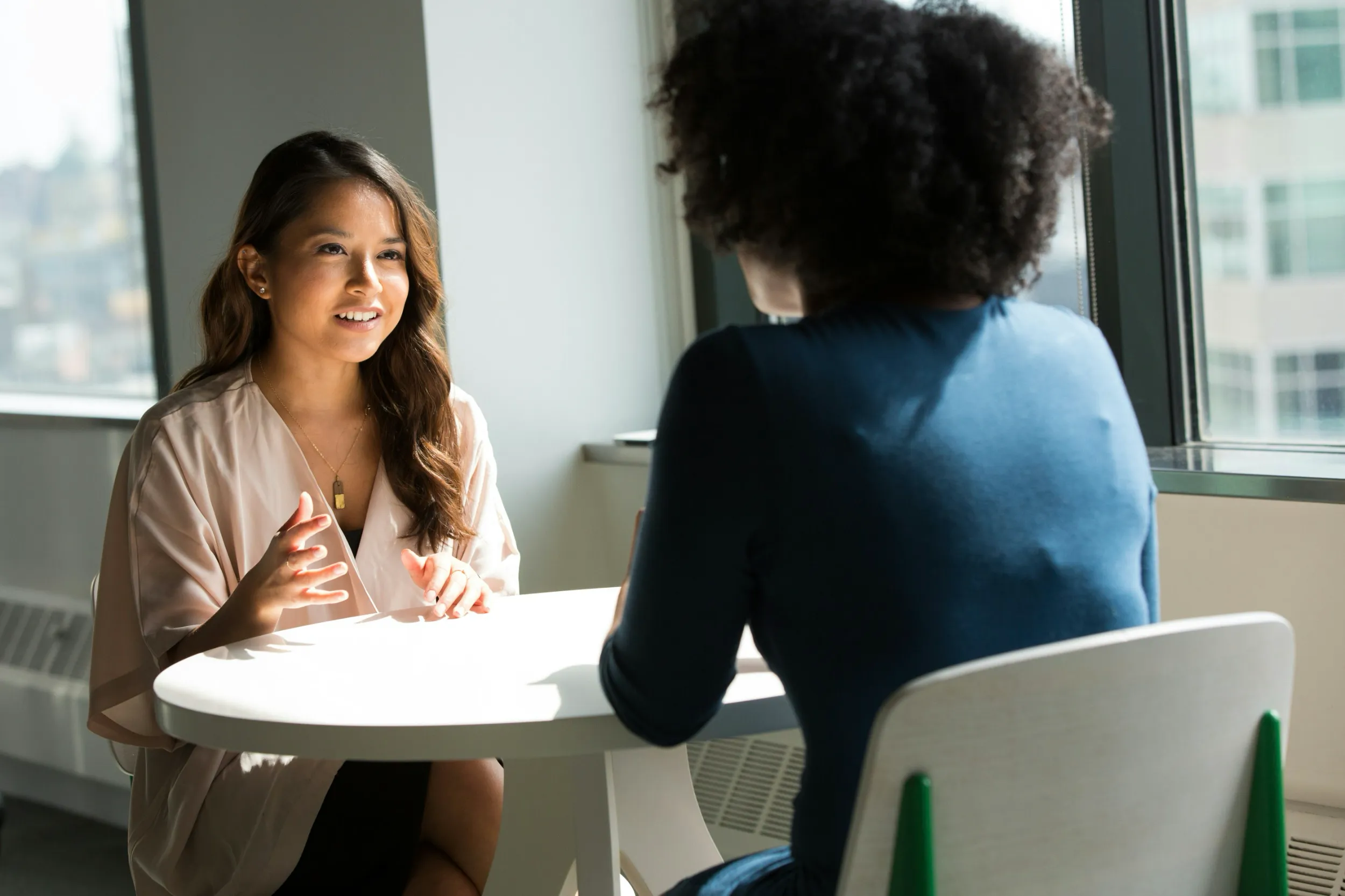 two people sitting at a table engaged in conversation